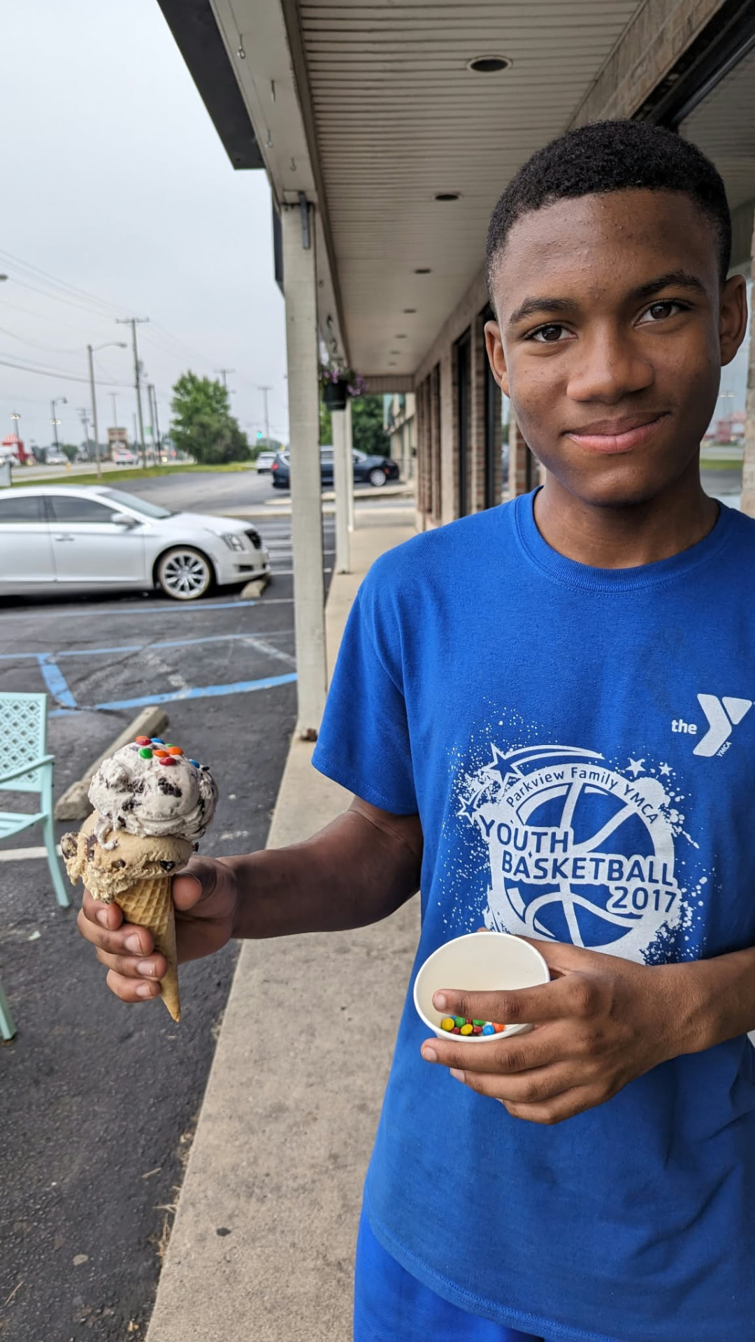 Jelani smiling with an ice cream cone and a small cup of candies